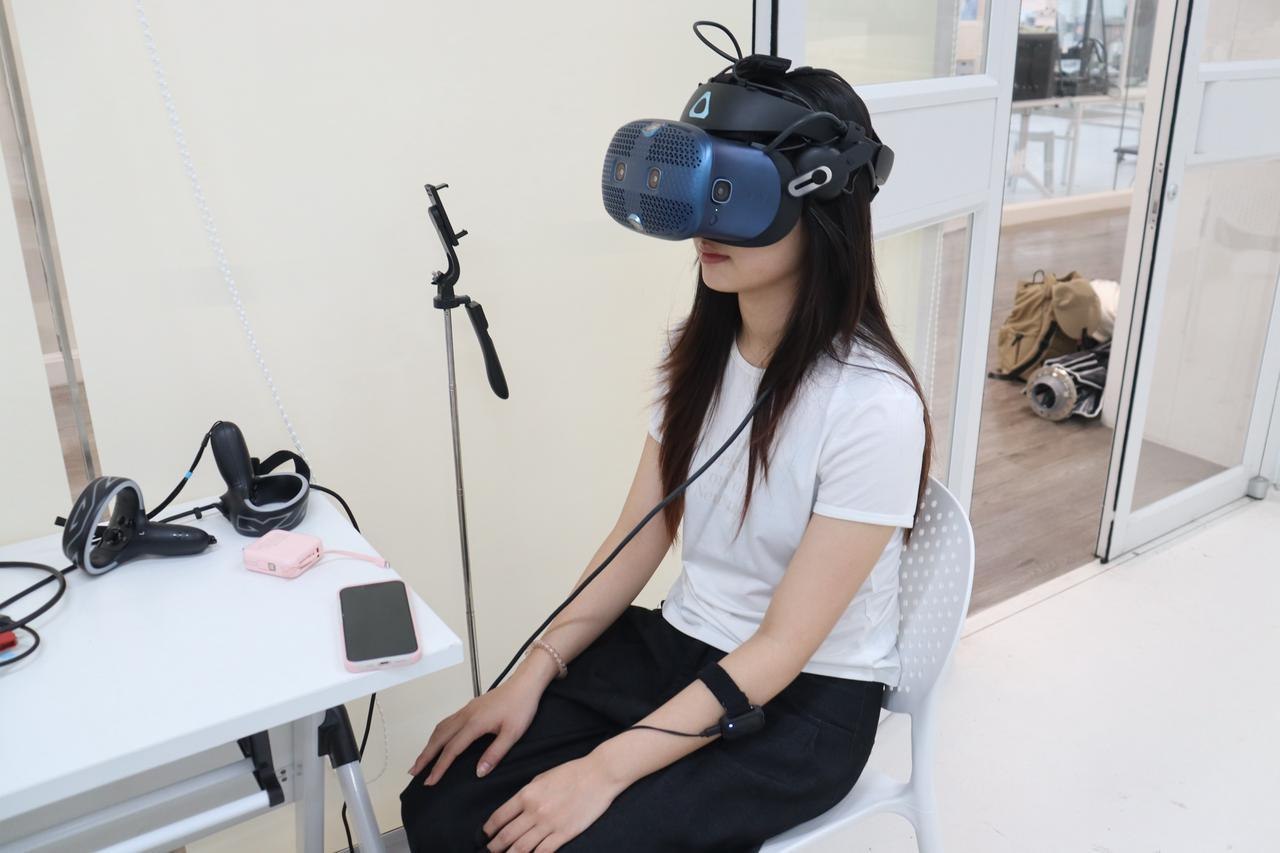 参与者在实验现场佩戴VR头显与腕部传感设备